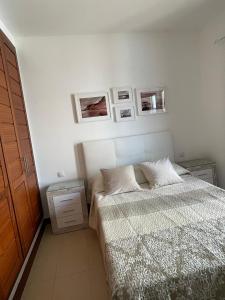 a bedroom with a bed and pictures on the wall at Dúplex Calero Sunset in Yaiza