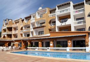 a hotel with a swimming pool in front of a building at Aldea 2 Cala Fornells in Paguera