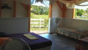 a room with a porch with a bed and a window at Gîtes Mosaïques in Sainte-Rose