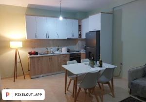 a kitchen with a white table and chairs in a room at Comfort Apartment in Tirana