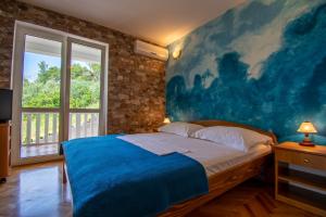1 dormitorio con 1 cama con una pintura en la pared en Apartmani Petracie, en Drvenik