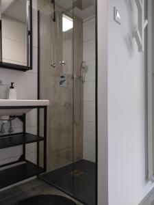 una ducha con una puerta de cristal junto a un lavabo en Pokoje Bumerang en Świnoujście
