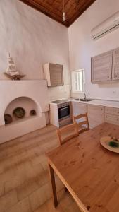a kitchen with a table and a kitchen with an oven at Kozas Art House, Symi in Symi