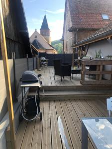 a wooden deck with a table on top of a building at L Atypik à L ancienne forge in Muhlbach-sur-Munster