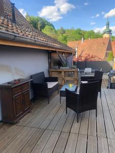 a patio with chairs and a table on a deck at L Atypik à L ancienne forge in Muhlbach-sur-Munster