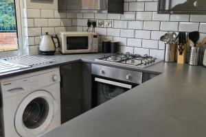 a kitchen with a microwave and a washing machine at Morris Lodge, Southampton - 1 bedroom, Free WIFI & Parking in Southampton