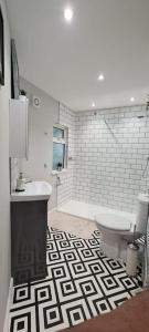 a bathroom with a black and white patterned floor at Morris Lodge, Southampton - 1 bedroom, Free WIFI & Parking in Southampton