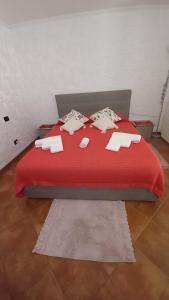 a red bed with a red blanket and pillows on it at Appartamento in zona residenziale in Orosei