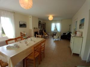ein Esszimmer und ein Wohnzimmer mit einem Tisch und Stühlen in der Unterkunft GITE FAMILIAL en baie du Mont S t Michel in Dragey