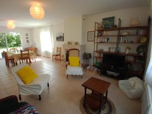 ein Wohnzimmer mit Möbeln und einem TV in der Unterkunft GITE FAMILIAL en baie du Mont S t Michel in Dragey