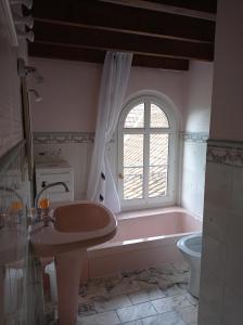 a bathroom with a tub and a sink and a window at GITE DU MOULIN in Renty