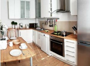 eine Küche mit weißen Schränken und einem Holztisch in der Unterkunft Haus-Wolter in Goslar