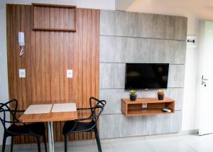 a living room with a dining table and a tv at Loft Rio Verde in Rio Verde
