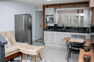 eine Küche und ein Wohnzimmer mit einem Sofa und einem Tisch in der Unterkunft Loft Rio Verde in Rio Verde