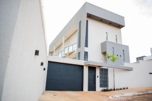 a white house with a garage at Loft Rio Verde in Rio Verde