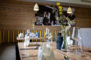 einen Tisch mit Gläsern und Blumen in einem Restaurant in der Unterkunft Der Alpenblick in St. Johann im Pongau