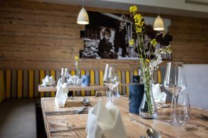 蓬高聖約翰的住宿－Der Alpenblick，餐厅里一张桌子,上面放着眼镜和鲜花