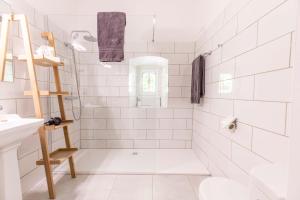 uma casa de banho branca com um chuveiro e um lavatório. em Château de Charmeil- Vichy chambres d'hôtes em Charmeil