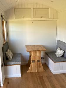 a table and two benches in a tiny house at The Snug at Coed Y Gaer in Oswestry