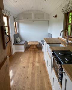 a kitchen with a table in the middle of a room at The Snug at Coed Y Gaer in Oswestry
