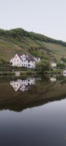 a house sitting next to a large body of water at Doppelzimmer an der Lahn ohne Küche in Obernhof