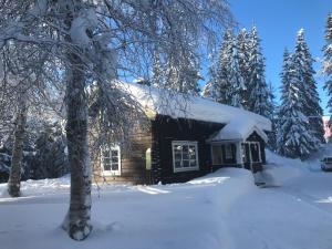 Cabaña de madera con nieve en el techo en Lillfallet mysig fjällstuga med bästa läge på fjället, en Sälen