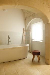 a white bath tub in a room with a window at Le mie mani in Martina Franca