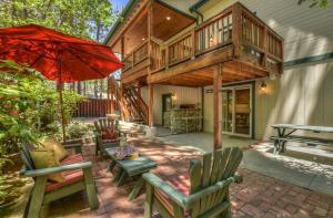 a house with a patio with chairs and an umbrella at 020 - Summit Haus in Big Bear Lake