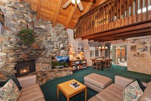 a living room with a stone wall and a fireplace at 020 - Summit Haus in Big Bear Lake