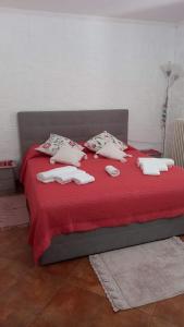 a red bed with towels and pillows on it at Appartamento in zona residenziale in Orosei