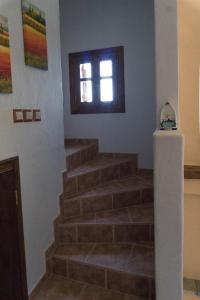 un conjunto de escaleras en una habitación con ventana en Katerina's Houses #2, en Centro histórico de Alónnisos