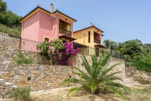a house on top of a stone wall with flowers at Katerina's Houses #2 in Alonnisos Old Town
