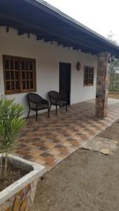 een patio met twee stoelen bovenop een huis bij Cabañas Los Laureles Ruta del vino bc in Ensenada