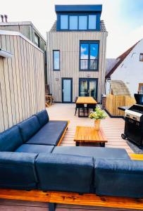 eine blaue Couch auf einer Terrasse mit einem Haus in der Unterkunft Catharine Suite in Breda