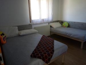 a room with two beds and a couch and a window at Casa Rosa dei Venti in Cividale del Friuli