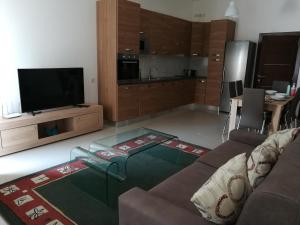 sala de estar con sofá y TV de pantalla plana en The Premier Suite - Fully Airconditioned - Ample Parking, en Naxxar
