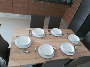 una mesa con platos blancos y cubiertos en The Premier Suite - Fully Airconditioned - Ample Parking, en Naxxar