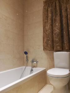un baño con inodoro y bañera en The Premier Suite - Fully Airconditioned - Ample Parking, en Naxxar