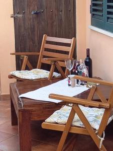 two wooden chairs and a table with wine glasses at Appartamento in zona residenziale in Orosei