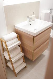 a bathroom with a sink and a wooden vanity with towels at Fado Apartments Gornja Radgona in Gornja Radgona