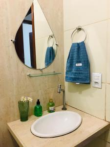 a bathroom sink with a mirror and a blue towel at Casa Aconchegante em Areia in Areia