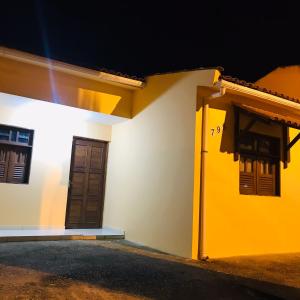 żółto-biały dom z drzwiami i oknami w obiekcie Casa Aconchegante em Areia w mieście Areia