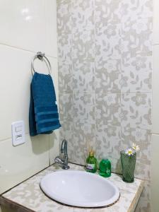 baño con lavabo y toalla azul en Casa Aconchegante em Areia, en Areia