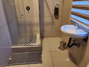 un baño con ducha y lavabo en Beloved Lodge, en Kimberley 16 fotos más