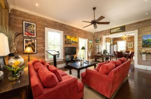 a living room with red furniture and a ceiling fan at The Mermaid & The Alligator in Key West