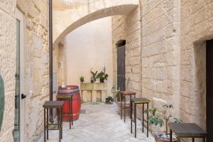 un patio con tavoli, sedie e botte di Casa Mamma Elvira a Lecce