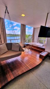 a living room with a swinging couch and a television at Pousada Carapeba in São Francisco