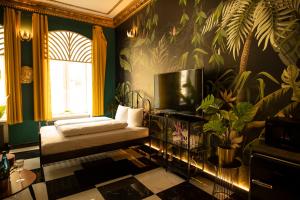 a room with a couch and a tv on a wall at Jungle Apartments in Wrocław