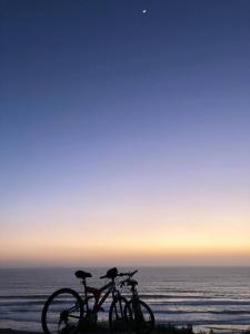 two bikes parked on the beach near the ocean at Recámara frente al mar, cama King, tv, wifi in Tijuana