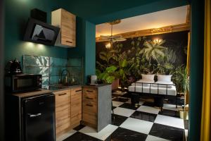 a kitchen with green walls and a black refrigerator at Jungle Apartments in Wrocław +81 photos